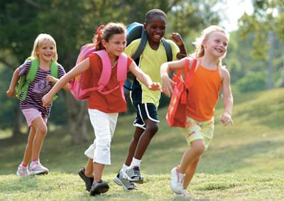children running with backpacks